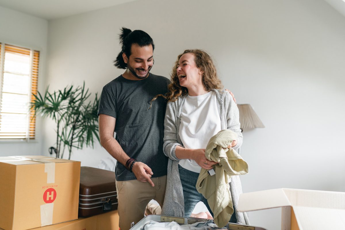 A couple laughing while unpacking boxes in their new home